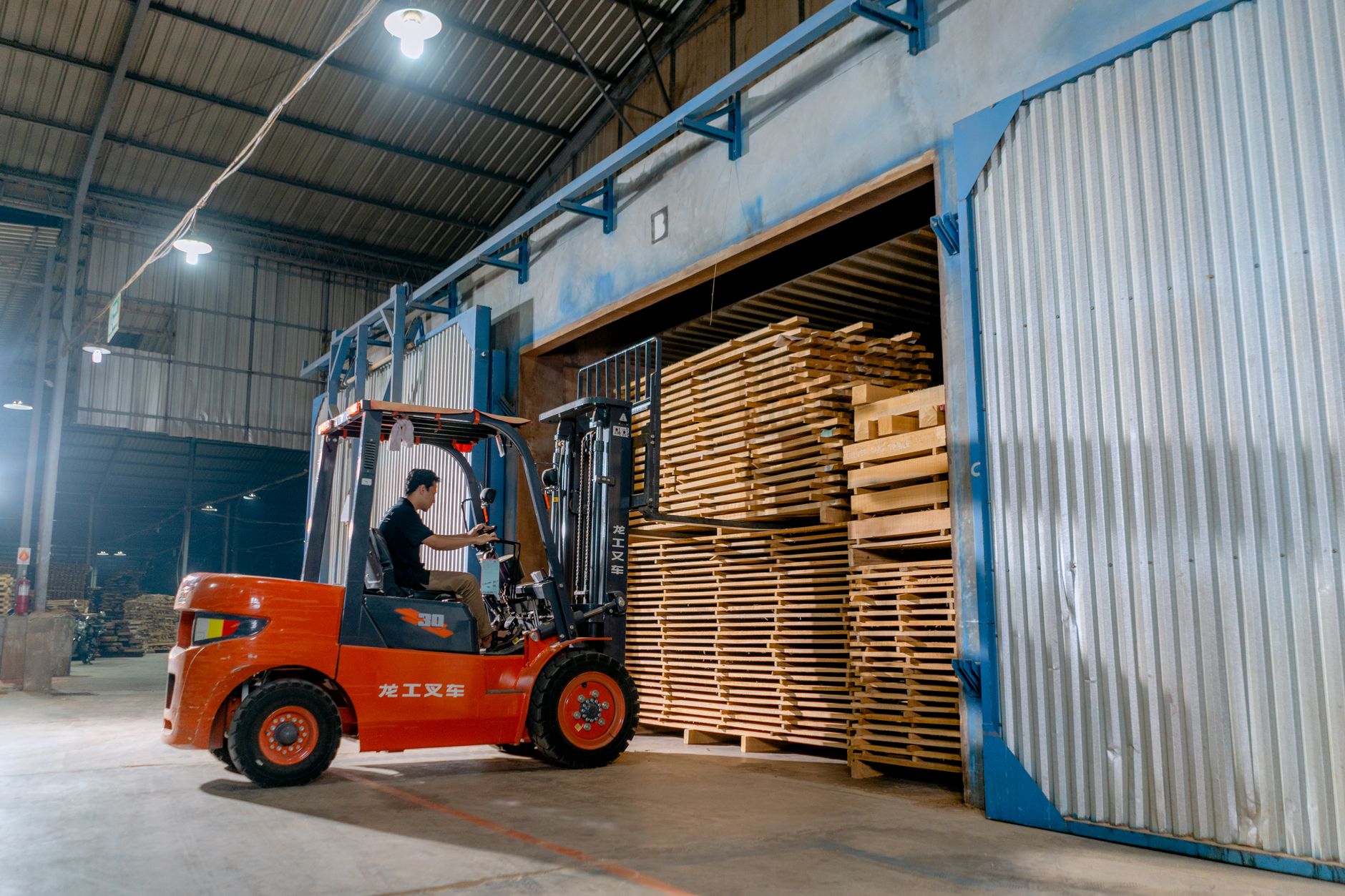Heftruck laadt pallets in een loods